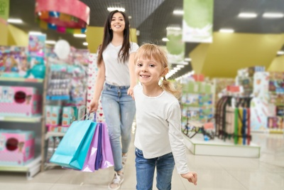 girl-keeping-hand-mom-running-forwardn-toy-store