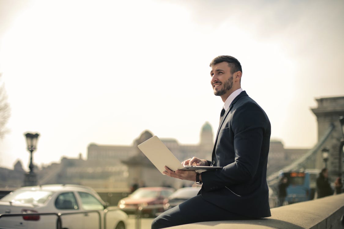 Man Wearing Black Suit While Using Laptop